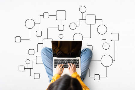 Top view of woman sitting on floor and using laptop with illustration business process and workflow...