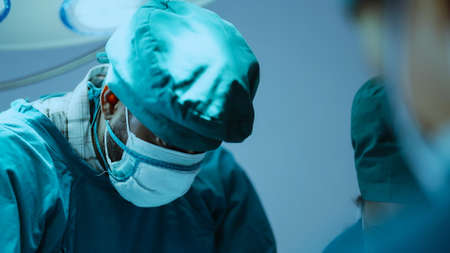 Surgery team operating in a surgical room. Doctor and nurse discuss planning surgeryの写真素材