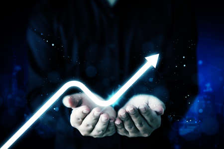 Business development to success and growing growth concept. Businessman hand holding virtual arrow graph corporate future growth planの写真素材