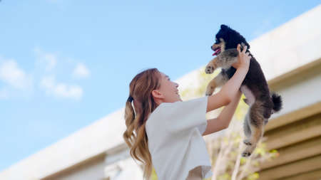Happy young asian woman holding her dog and happy smile in the park. Pet lover conceptの写真素材