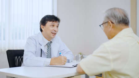Doctor and patient are discussing consultation about symptom problem diagnosis of disease talk to the patientの写真素材