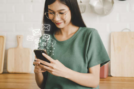 Email marketing and newsletter concept. Woman using mobile smartphone and sending online message...