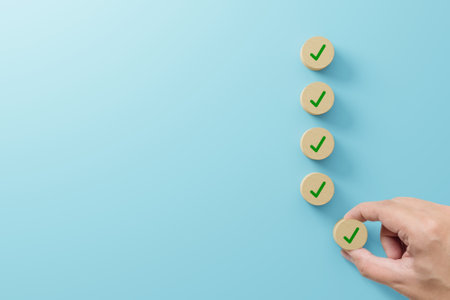 Checklist and check mark concept. Check mark on wooden blocks on light blue backgroundの写真素材