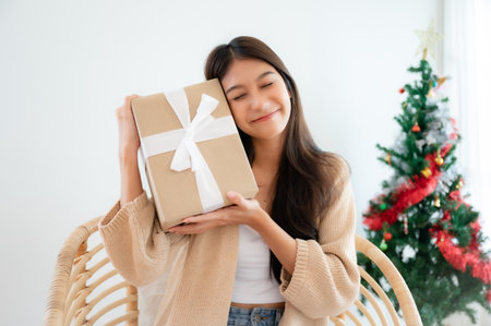 Young asian woman happy and smile while opening gift box. Happy new year, Thanksgiving, Merry Christmasの写真素材