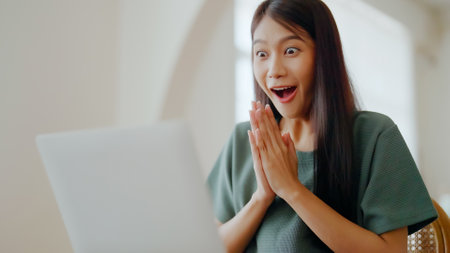 Excited asian female feeling euphoric celebrating online win success achievement result, young woman happy about good email news, motivated by great offer or new opportunity, passed exam, got a jobの写真素材