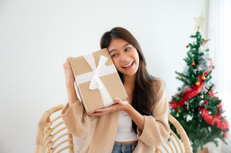Young asian woman happy and smile while opening gift box. Happy new year, Thanksgiving, Merry Christmasの写真素材
