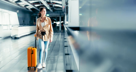 International airport terminal. Asian beautiful woman with luggage and walking in airportの写真素材
