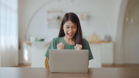 Excited asian female feeling euphoric celebrating online win success achievement result, young woman happy about good email news, motivated by great offer or new opportunity, passed exam, got a jobの写真素材