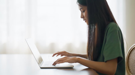 Young asian woman working at home. Female using computer laptop on desk at houseの写真素材