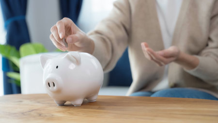 Asian woman putting coin in piggy bank. Save money and investment concept