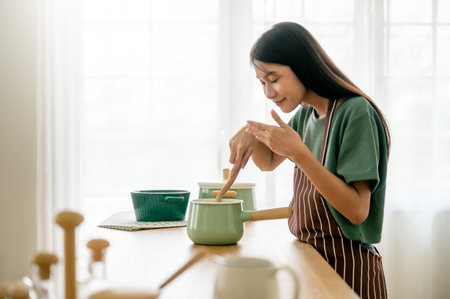 Young beauty asian woman cooking in kitchen room at homeの写真素材