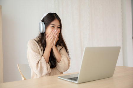 Young asian woman wearing headset while working on computer laptop at house. Work at home, Video conference, Video call, Student learning online classの写真素材