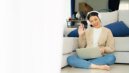 Young asian woman wearing headset while working on computer laptop at house. Work at home, Video conference, Video call, Student learning online classの写真素材