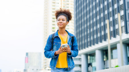 Black young woman, using smart phone and smile with walking in the city outdoor. Happy african student, young female walking with mobile by a buildingの写真素材
