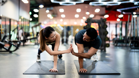 Athletic Sportsman and Sportswoman Doing Push Ups Together at Fitness Gym: Strength, Unity, and Motivationの写真素材