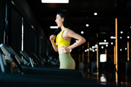 Young Asian Woman Running on Treadmill - Fitness Gym Exerciseの写真素材
