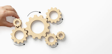 Business process and workflow automation with flowchart. Hand holding wooden cog flowing process management on white backgroundの写真素材