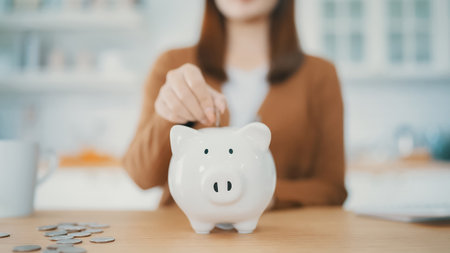 Young Asian woman putting coin in piggy bank. Save money and financial investmentの写真素材