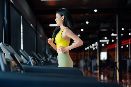 Young Asian Woman Running on Treadmill - Fitness Gym Exerciseの写真素材