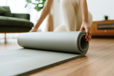 Young Asian woman doing yoga, twisting on a mat in the living room at homeの写真素材
