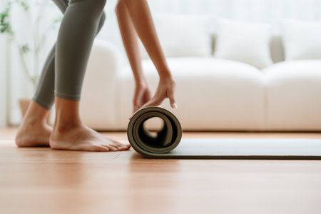 Young Asian woman doing yoga, twisting on a mat in the living room at homeの写真素材
