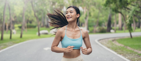 Young runner Asian woman jogging in park path, skinny fit in sports wear outfit leggings and top