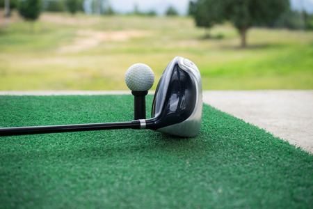 Close-up of a golf ball and a golf wood on a driving rangeの写真素材