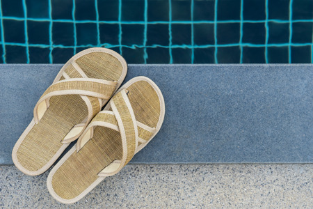 slippers beside swimming poolの写真素材