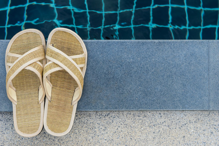 slippers beside swimming poolの写真素材