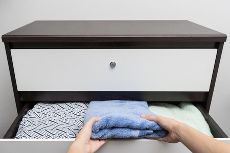 Woman hand open drawer and picking up Towel
