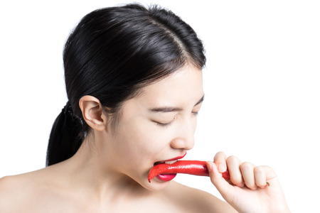 Beautiful young woman playing/eating pepper  ,isolated (Focus Eye)の写真素材