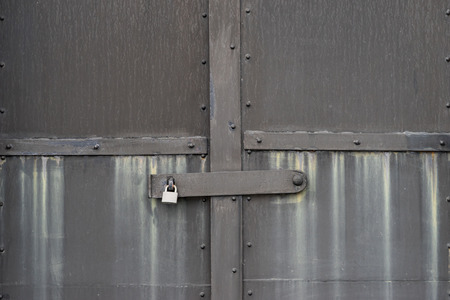 the grey steel door with padlockの写真素材