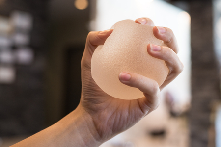 Silicone breast implant on handsの写真素材