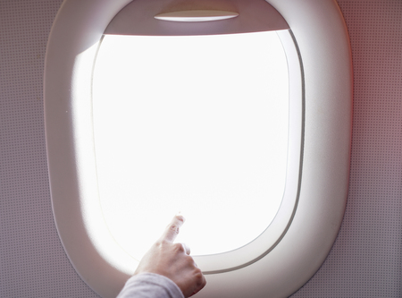 Female Hand Pointing Out of Plane Windowの写真素材