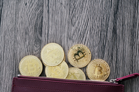 Top view of the golden bitcoins on the red leather walletの写真素材