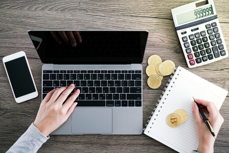 Laptop with calculator and golden bitcoin. Cryptocurrency investors concept.の写真素材