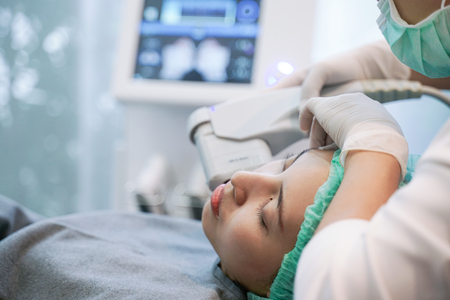 Laser or frequency Skin Tightening Face Lift treatment procedure involves.Young woman receiving laser chin.の写真素材