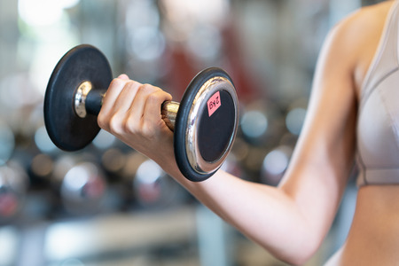 Close up women with dumbbells in hands the gymの写真素材