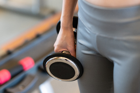 Close up women with dumbbells in hands the gymの写真素材