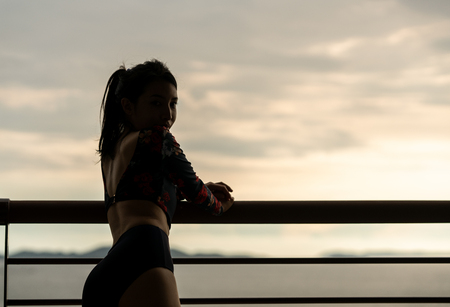 Young female relaxing on the balcony  with sunsetの写真素材