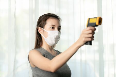 Woman use thermometer to check people  for protect corona virus. Use digital thermometer checking...