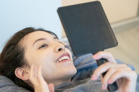 Woman looking in the mirror admiring herself, After or before Plastic aesthetic facial surgery in beauty clinic.の写真素材