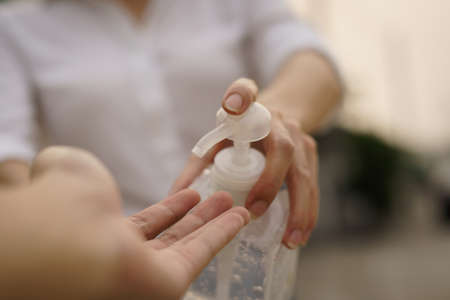 Woman sharing alcohol gel or sanitizer gel for washing hands, corona virus or Covid-19 protection.の写真素材