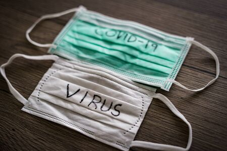Surgical mask with corona virus (covid-19) text written.の写真素材