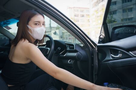 Wome wearing surgical mask in the car, for corona virus or Covid-19 protection.の写真素材