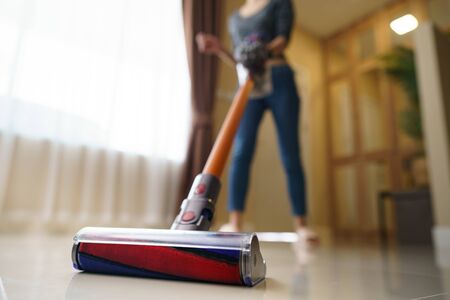 Woman use vacuum cleaner cleaning on floor.の写真素材