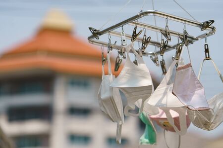 Surgical mask hanging from a drying rack after use and wash. Concept reusing masks.の写真素材