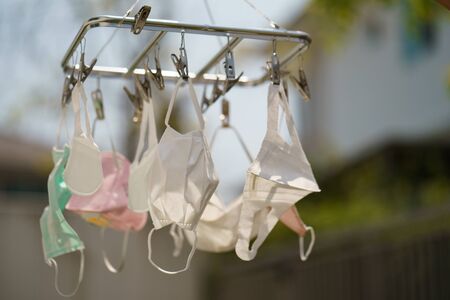 Surgical mask hanging from a drying rack after use and wash. Concept reusing masks.