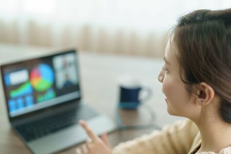 Woman using laptop making video call to partner, looking at screen with conference. work from home.の写真素材
