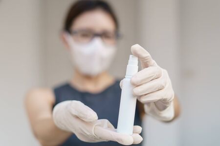 Woman hand using sanitizer spray, alcohol spraying disinfectant to stop spreading  coronavirus or COVID-19.の写真素材